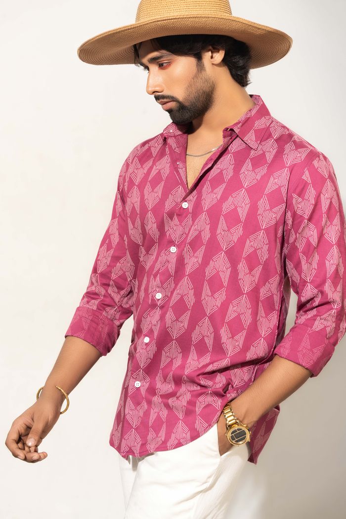 room-03 Fashionable man wearing a red printed shirt, sunhat, and accessories in a studio shot.